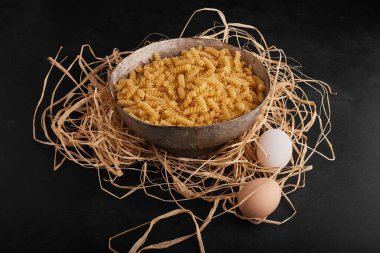 Etrafında yumurtalar olan metal bir kasede makarna. Yüksek kalite fotoğraf