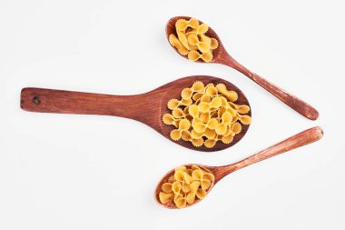 Beyaz arka planda tahta kaşıklarda çiğ makarna. Yüksek kalite fotoğraf