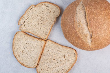 Ekmek dilimleri ve mermer arka planda tam ekmek. Yüksek kalite fotoğraf