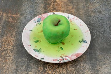 Yeşil elma yeşil suda, mermer zeminde güzel bir tabakta. Yüksek kalite fotoğraf