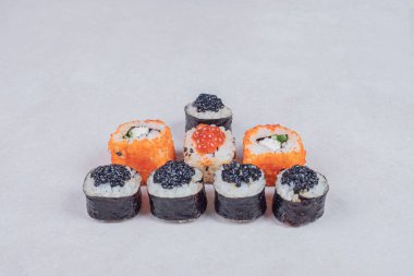 Maki ve California suşisi beyaz arka planda yuvarlanıyor. Yüksek kalite fotoğraf