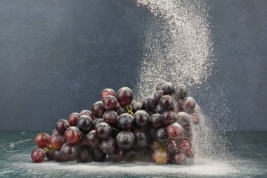 Mermer masa üzerinde toz ile süslenmiş siyah üzümler. Yüksek kalite fotoğraf