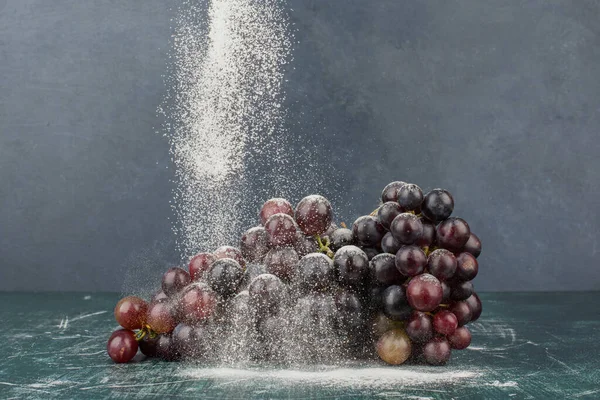 Mermer masa üzerinde toz ile süslenmiş siyah üzümler. Yüksek kalite fotoğraf