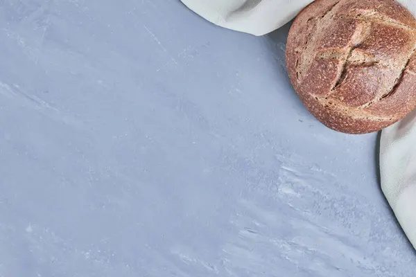 Mavi arka planda el yapımı yuvarlak ekmek ekmeği. Yüksek kalite fotoğraf