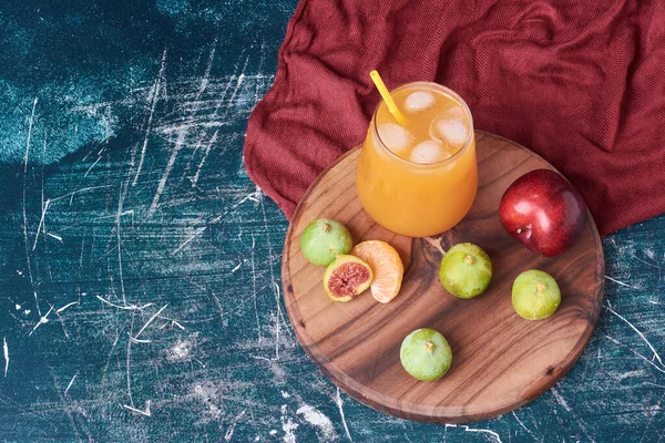 Fruits with a cup of drink on blue background. High quality photo