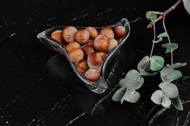 Badem kabuklu, cam bardaklı, siyah arka planda. Yüksek kalite fotoğraf