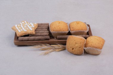 Tahta tahtada beyaz arka planda lezzetli kekler. 