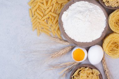 Tahta kaselerde, yumurta sarısı ve unla pişirilmemiş makarna. Yüksek kalite fotoğraf