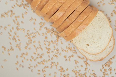 Beyaz zemin üzerinde yulaf taneleri olan dilimlenmiş taze beyaz ekmek. Yüksek kalite fotoğraf