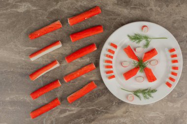 Yeşillikli yengeç çubukları ve beyaz tabakta limon. Yüksek kalite fotoğraf