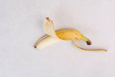 Beyaz masada soyulmuş tek bir muz. Yüksek kalite fotoğraf