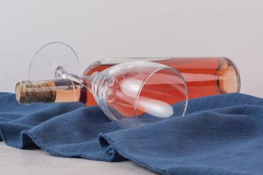 Mavi masa örtüsünün üzerinde bir şişe gül şarabı ve bardak. Yüksek kalite fotoğraf