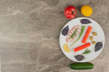 Bir tabak yengeç çubuğu, domates, salatalık ve limon. Yüksek kalite fotoğraf