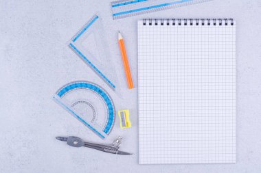 Gri arkaplanda boş bir kağıt parçasıyla çizim araçları. Yüksek kalite fotoğraf