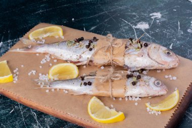 Limon dilimleri, biber taneleri ve ahşap tahtada tuz ile çiğ balık. Yüksek kalite fotoğraf