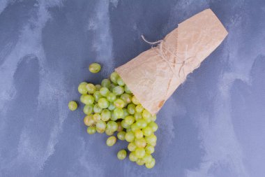 Mavi arka planda kağıttan yapılmış yeşil üzümler. Yüksek kalite fotoğraf