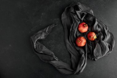 Siyah masa örtüsü üzerine kırmızı nar, üst manzara. Yüksek kalite fotoğraf