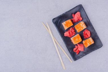 Philadelphia siyah seramik tabakta kırmızı zencefille yuvarlanıyor. Yüksek kalite fotoğraf