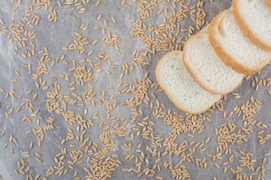 Dilimlenmiş tost ekmeği ve mermer arka planda yulaf taneleri. Yüksek kalite fotoğraf
