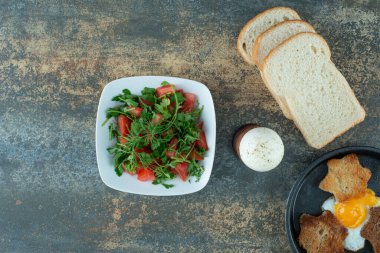 Dilimlenmiş ekmek ve mermer arka planda haşlanmış yumurta ile lezzetli salata. Yüksek kalite fotoğraf