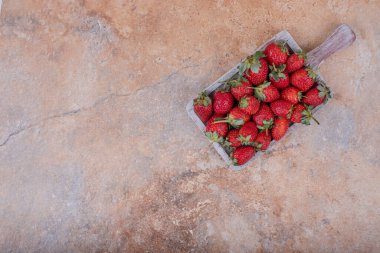 Kırsal gri ahşap tabakta kırmızı çilekler. Yüksek kalite fotoğraf