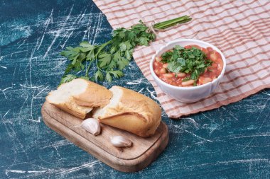 Tahta bir tahtanın üzerinde baget ekmeğiyle servis edilen sebze çorbası. Yüksek kalite fotoğraf