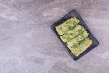 Siyah bir tabakta içi ot ve baharatla dolu lahana ambalajı. Yüksek kalite fotoğraf