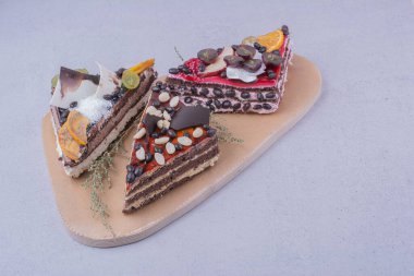 Kek dilimleri karamel, çikolata ve fındıklar ahşap bir tabakta. Yüksek kalite fotoğraf