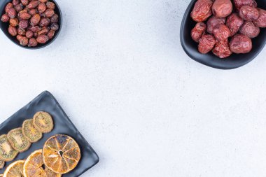 Kurutulmuş gül kalçası, gümüş çilek, kivi ve mermer yüzeyde portakallar. Yüksek kalite fotoğraf