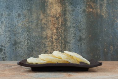 Kurutulmuş sağlıklı ananasla dolu siyah bir tabak. Yüksek kalite fotoğraf