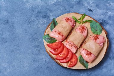 Çiğ tavuk fileto ve sebzeler ahşap bir tahta üzerinde mavi arka planda. Yüksek kalite fotoğraf