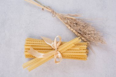 Beyaz arka planda kurdeleyle bağlanmış pişmemiş makarna. Yüksek kalite fotoğraf