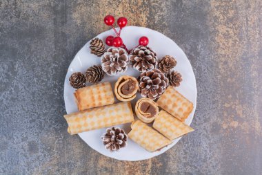 Beyaz tabakta kozalaklı tatlı hamur işi.