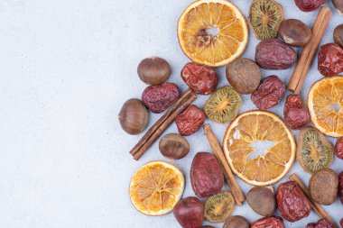 Kurutulmuş meyve, tarçın çubukları ve mermer yüzeyde kestane. Yüksek kalite fotoğraf