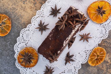 Kurumuş portakallı bir dilim pasta ve beyaz arka planda yıldızlar.