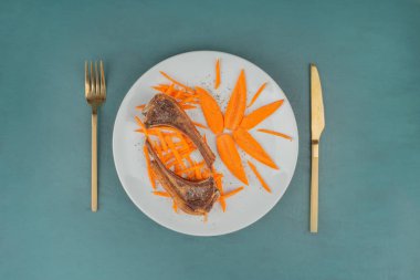 Beyaz tabakta kuzu pirzolası ve havuç dilimleri. Yüksek kalite fotoğraf