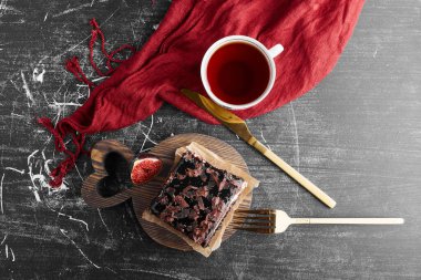 Beyaz tabakta bir dilim çikolatalı cheesecake, incir ve bir fincan çay. Yüksek kalite fotoğraf