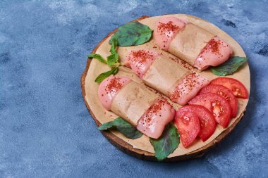 Çiğ tavuk fileto ve sebzeler ahşap bir tahta üzerinde mavi arka planda. Yüksek kalite fotoğraf