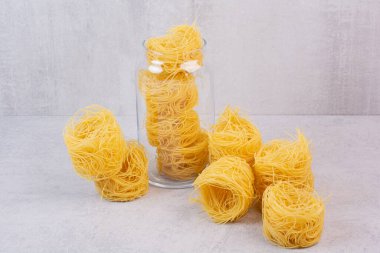 Mermer zemin üzerinde cam kavanozda pişmemiş spagetti yuvaları. Yüksek kalite fotoğraf