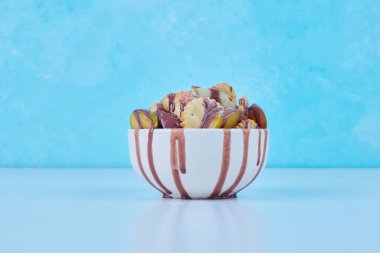 Ortasında çikolata şurubu olan beyaz bir seramik kasede krakerler. Yüksek kalite fotoğraf