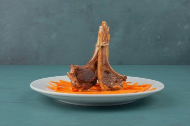 Beyaz tabakta kuzu pirzolası ve havuç dilimleri. Yüksek kalite fotoğraf