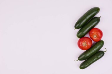 Beyaz arka planda iki domates ve dört salatalık izole edilmiş. Yüksek kalite fotoğraf
