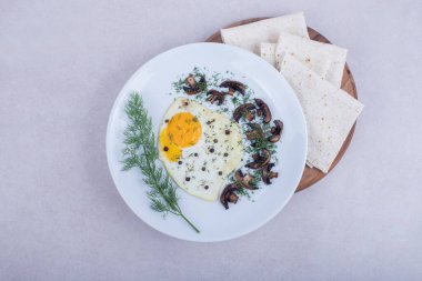 Kızarmış mantarlı omlet ve beyaz tabakta pita ekmeği. Yüksek kalite fotoğraf