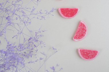 Yüzeyde bitkilerle kırmızı reçelli şekerler. Yüksek kalite fotoğraf