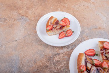 Etrafında meyveler olan beyaz bir tabakta çilekli turta. Yüksek kalite fotoğraf