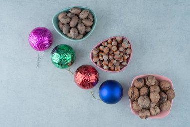 Mermer arka planda Noel topları olan üç küçük tabak fındık. Yüksek kalite fotoğraf