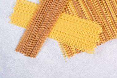 Beyaz arka planda iki adet çiğ spagetti makarna. Yüksek kalite fotoğraf