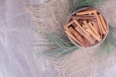 Çuval bezi üzerinde tahta bir kaba tarçın çubukları. Yüksek kalite fotoğraf
