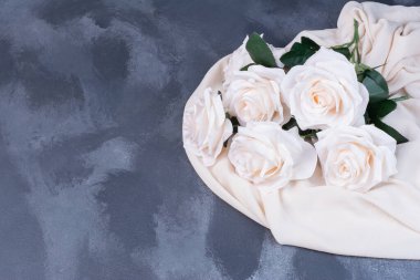 Mavi arka planda saten kumaşlı yapay beyaz çiçekler. Yüksek kalite fotoğraf