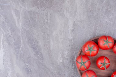 Tahta bir tabakta izole edilmiş kırmızı domatesler. Yüksek kalite fotoğraf